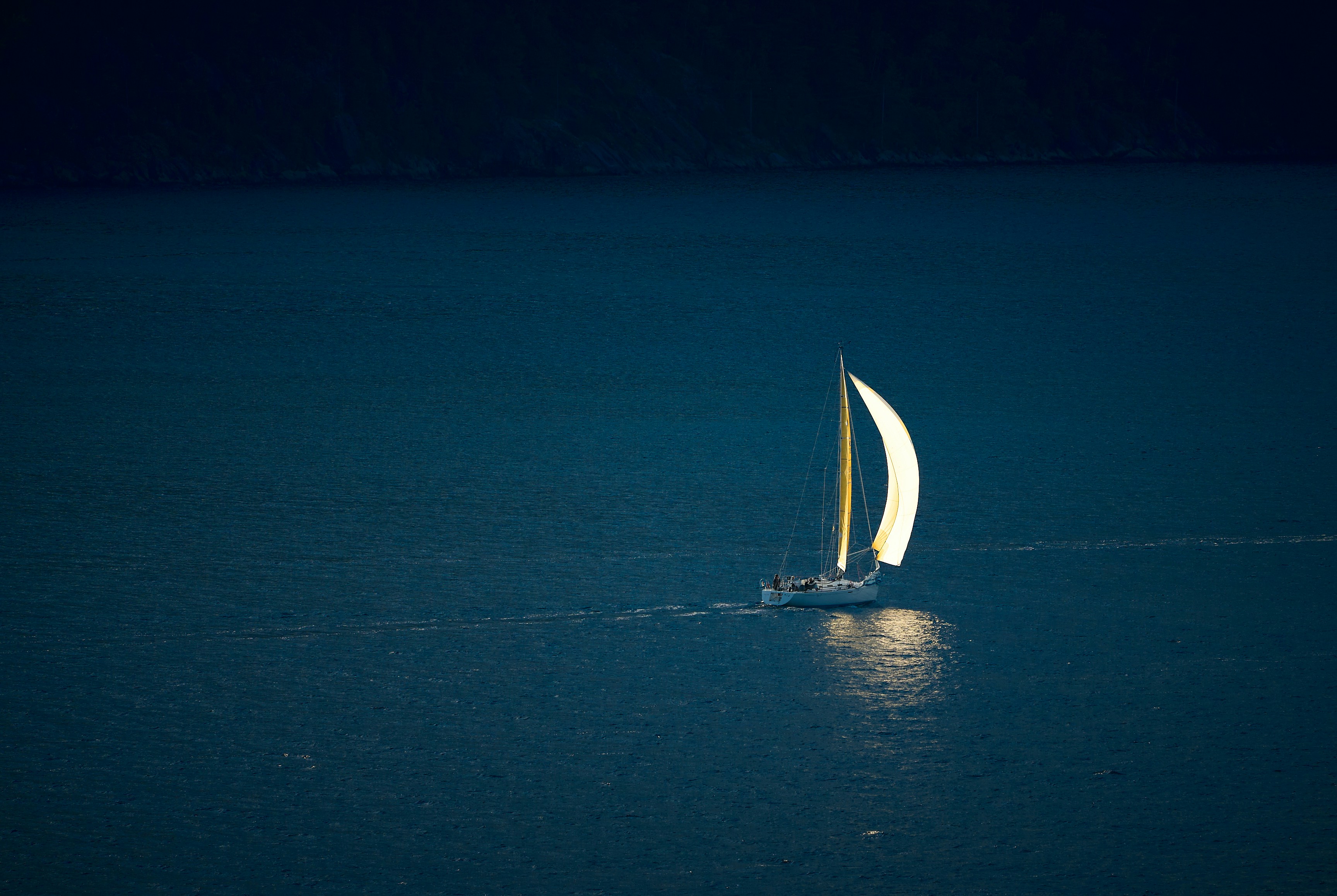 A sailboat in the middle of the ocean at night